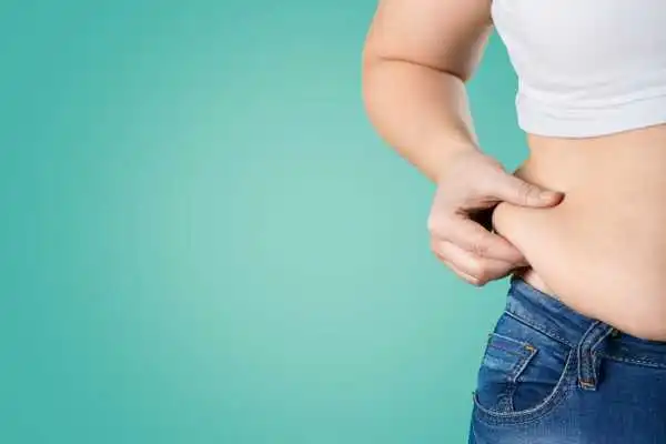 Image of woman pinching her love handles to show weight gain Wolverhampton
